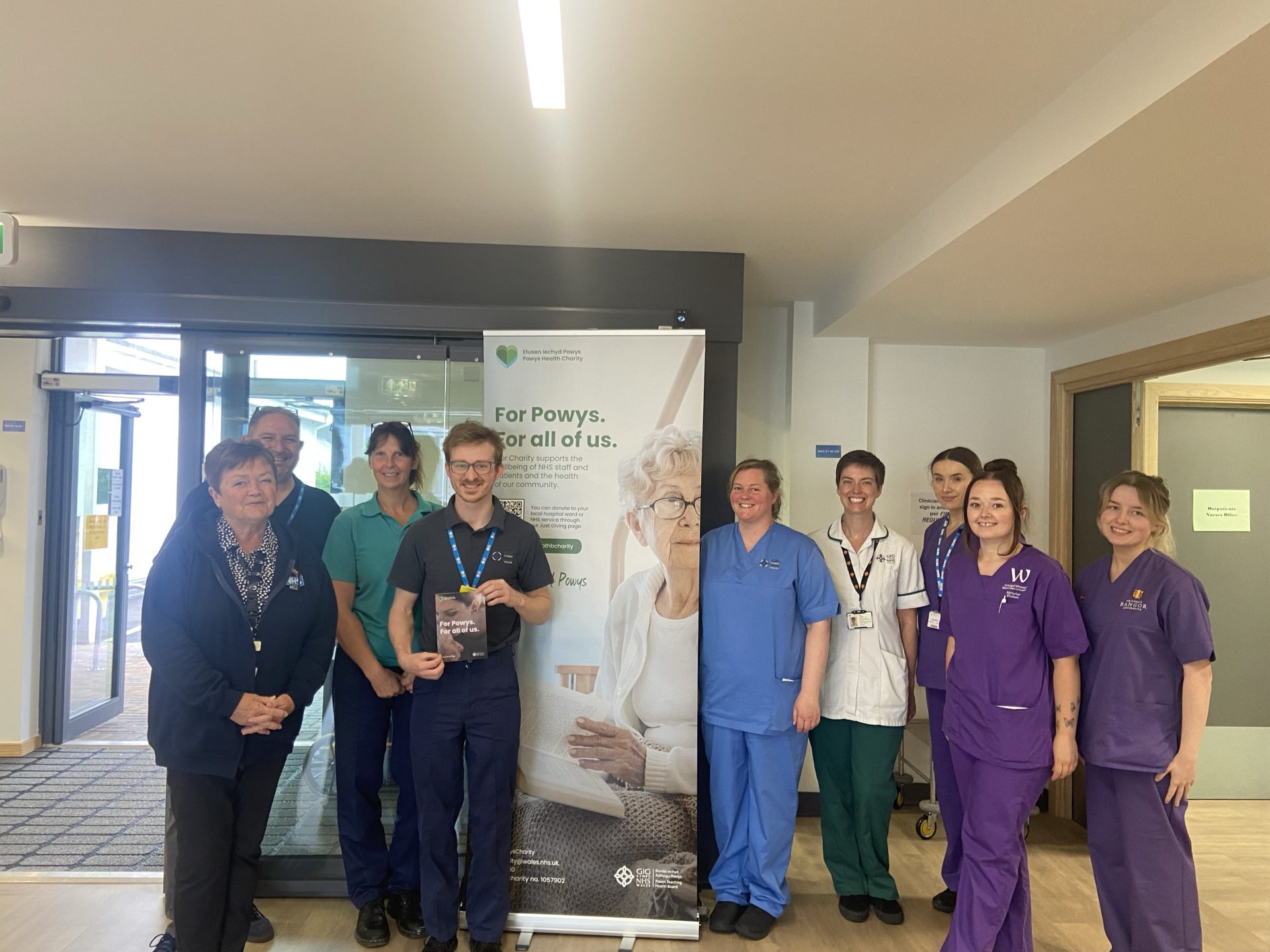 Image of Powys Health Charity Staff on visit to Machynlleth Hospital along with several Staff members.